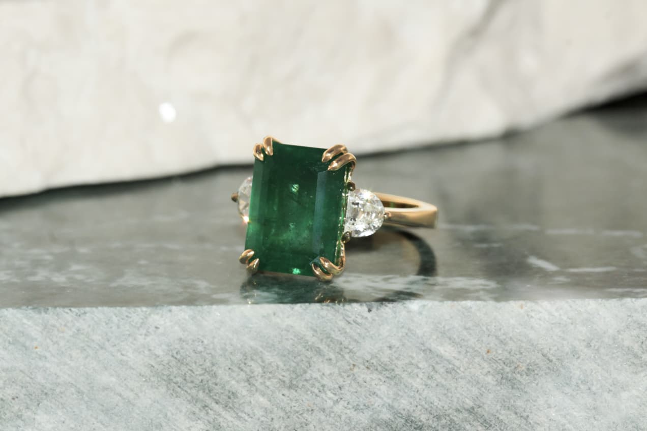 Maison Mirath bespoke emerald ring with a 7.40 carat emerald-cut emerald and 0.67 carats of half moon diamonds set in 18k yellow gold 