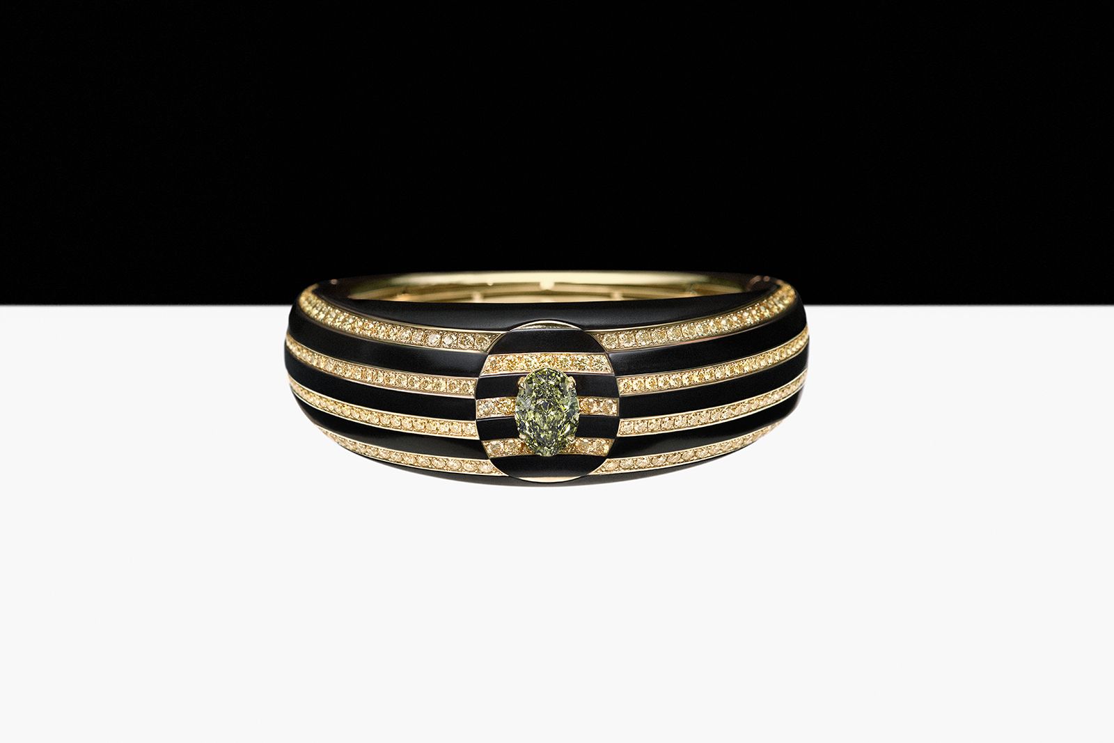 De Beers Optical Wonder bracelet from The Alchemist of Light High Jewellery collection with yellow round brilliant pavé-set diamonds, black aluminium and a 3.02 carat fancy deep greyish green oval-shaped diamond