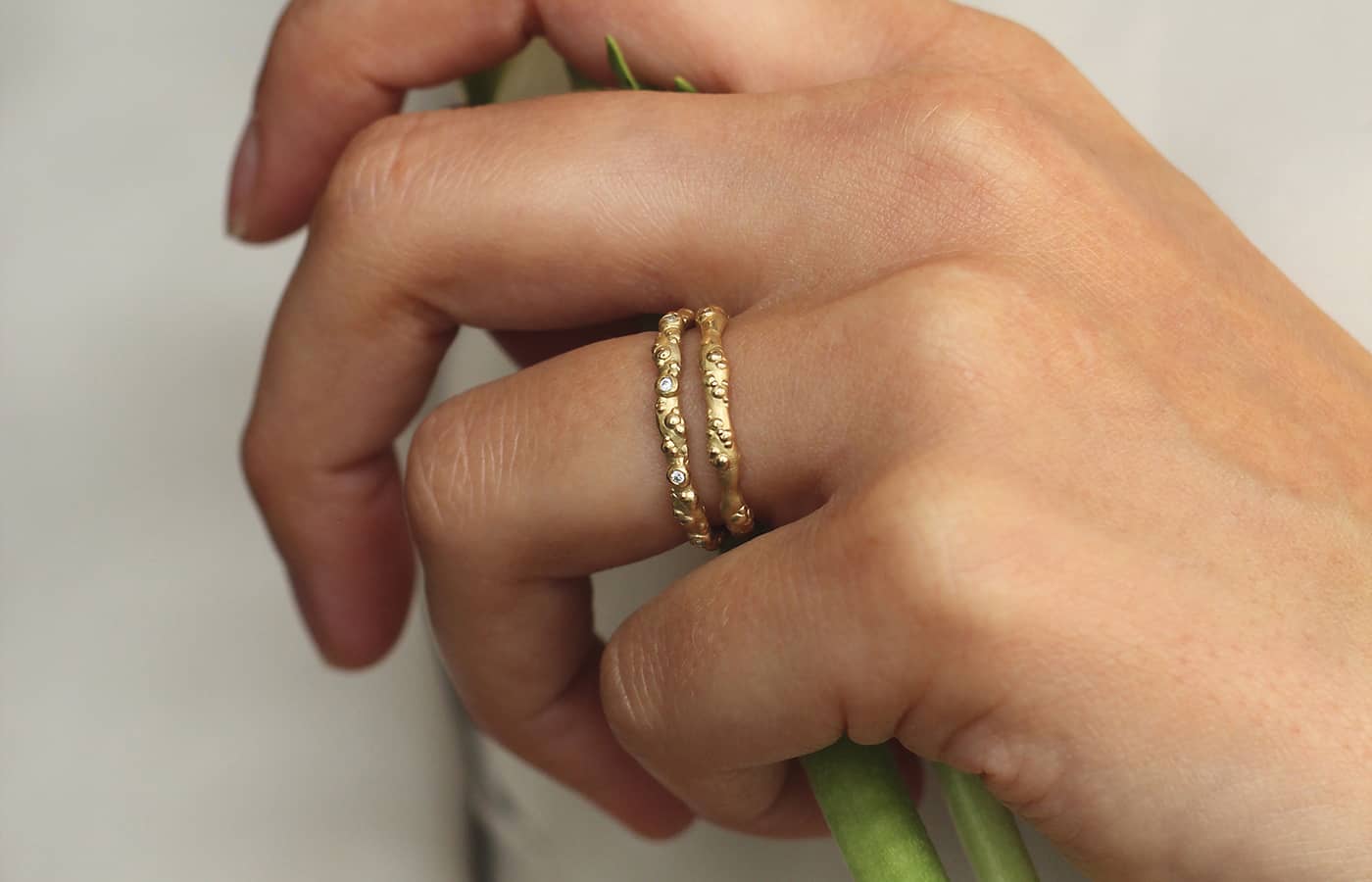  Model wearing Judith Peterhoff 18k yellow gold and diamond Orno slim diamond wedding band with a 18k yellow gold Orno slim wedding band  