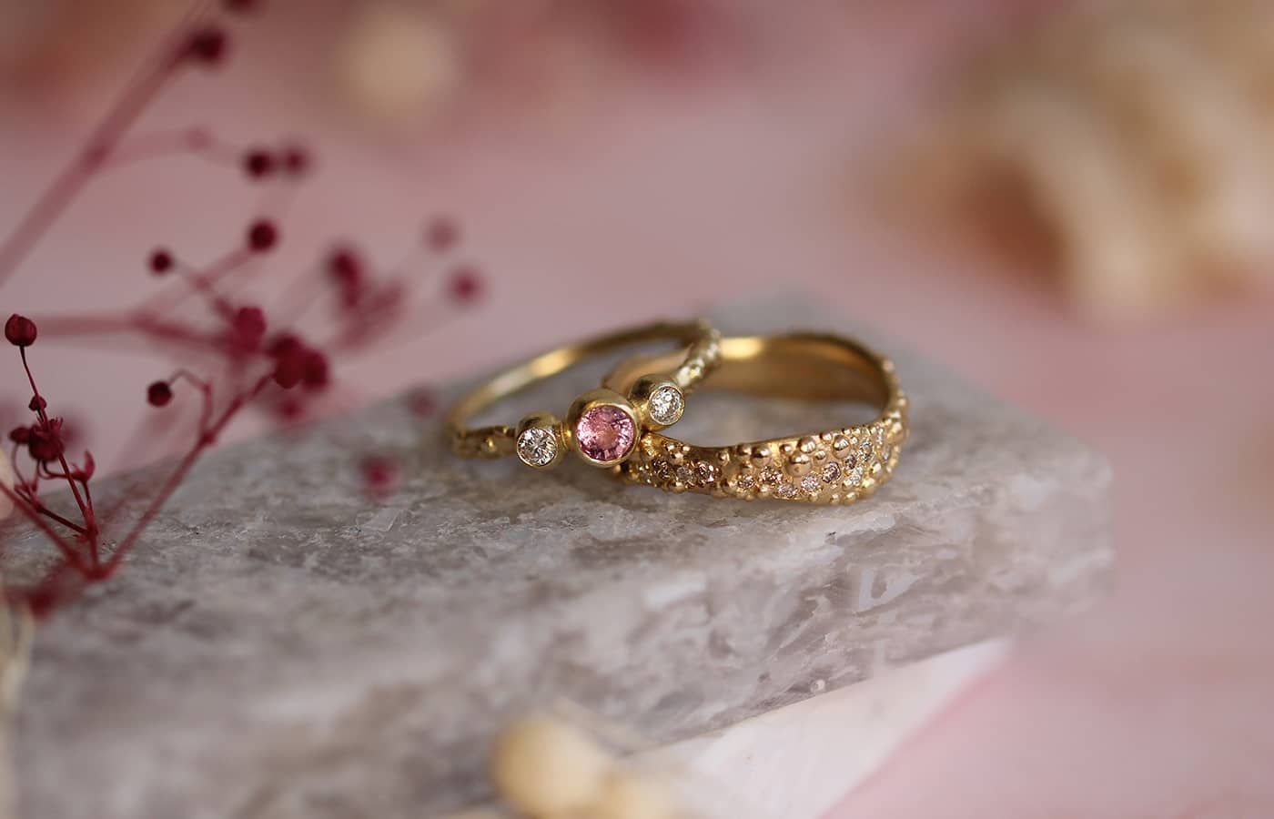 Judith Peterhoff 14k yellow gold Orno Three Stone commitment ring with Padparadscha pink sapphire and diamonds and 9k yellow gold Orno wide commitment band with 0.46ct champagne and white diamonds
