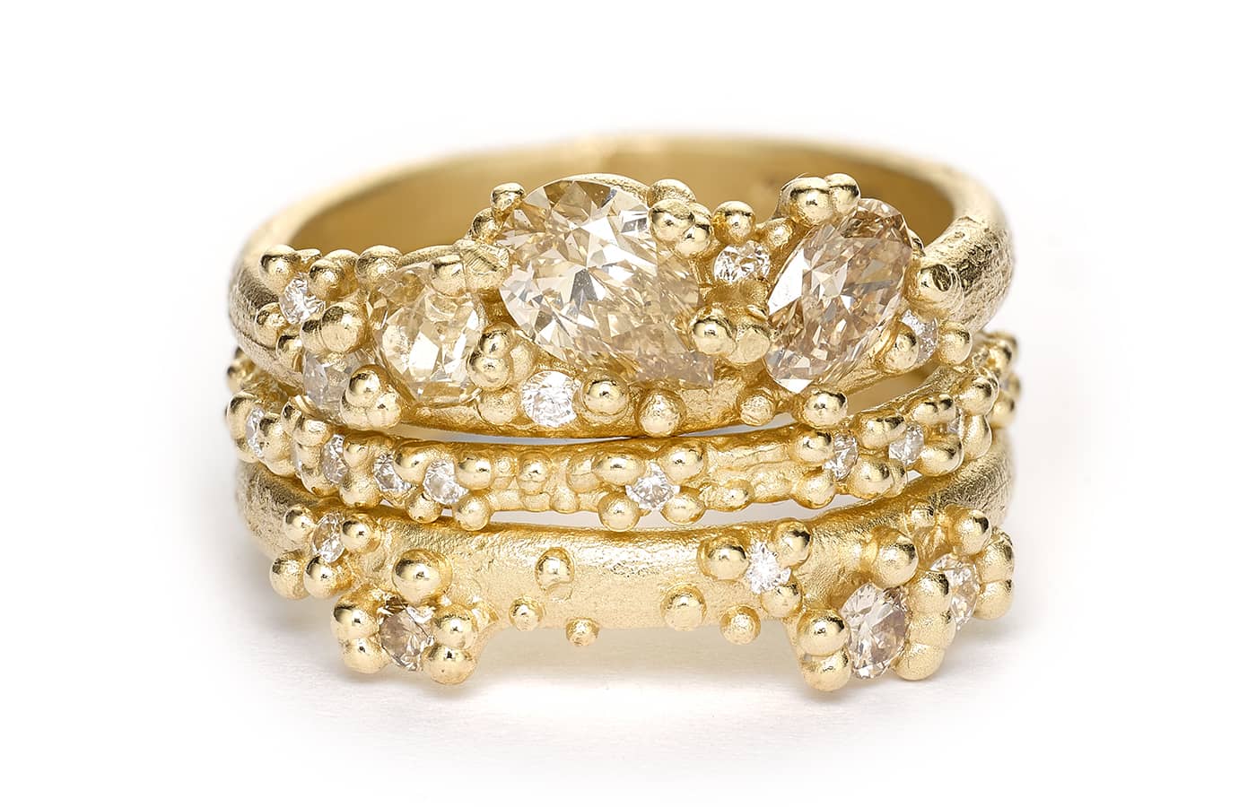  A stack of 14k yellow gold Ruth Tomlinson rings set with champagne and white diamonds
