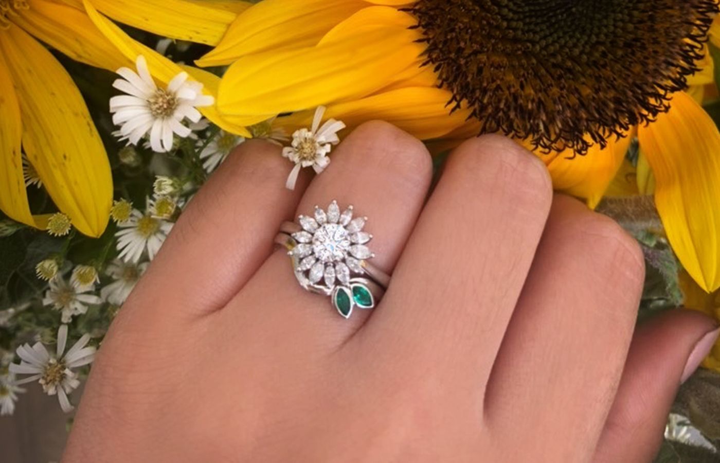  77 Diamonds bespoke diamond Sunflower ring, stacked with a band set with marquise-cut emeralds 