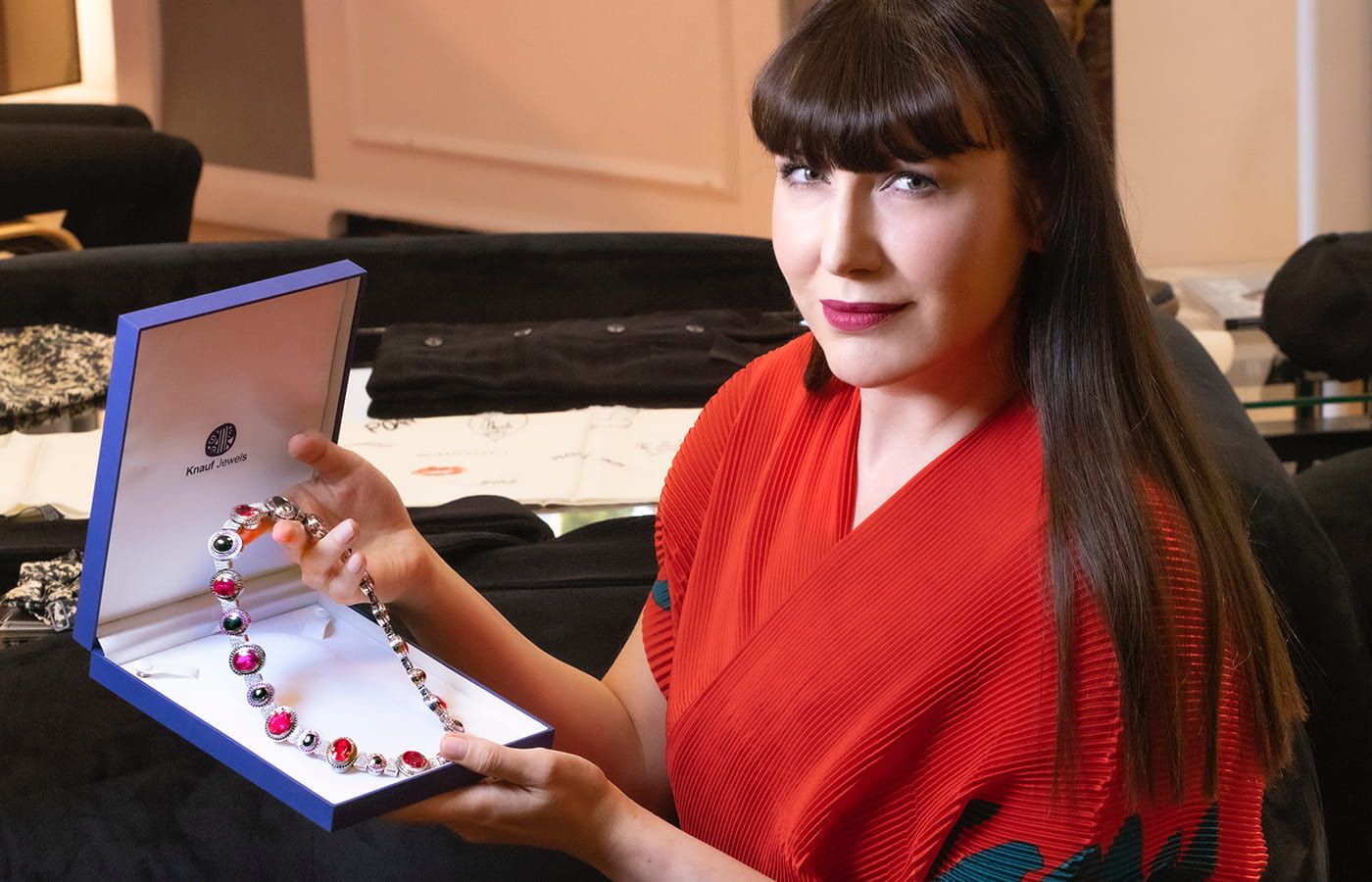 Katerina Perez holds a coloured gemstone necklace by Nathalie Knauf Jewels