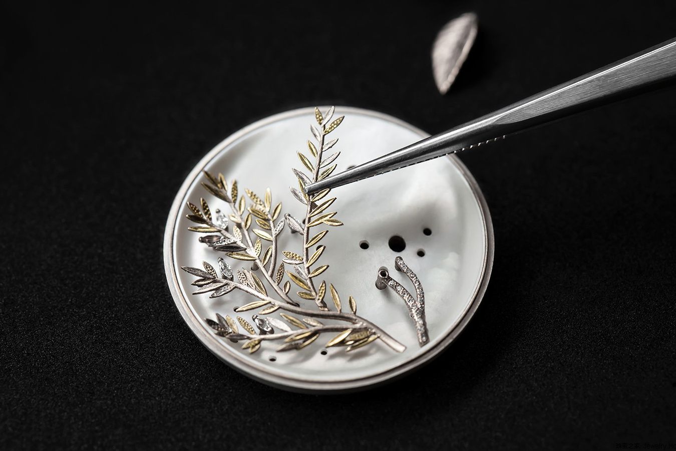  The dial of the Dior Grand Soir Herbier N°2 features mother-of-pearl adorned with yellow gold, round-cut, pear-cut, marquise-cut and triangle-cut diamonds, cabochon-cut mother-of-pearl and feathers 