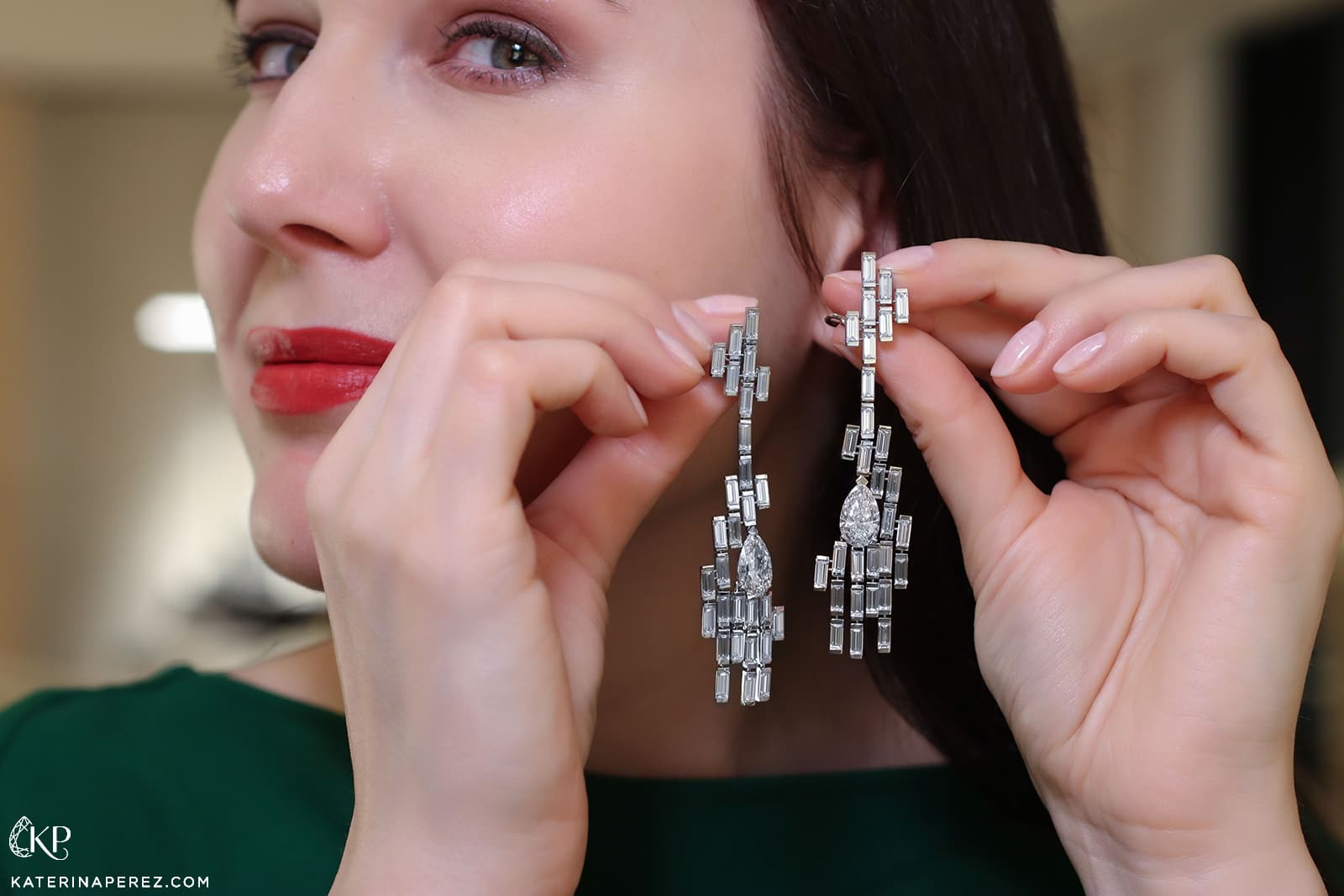 Katerina Perez holding pear-cut and baguette diamond High Jewellery earrings by Bucherer Fine Jewellery