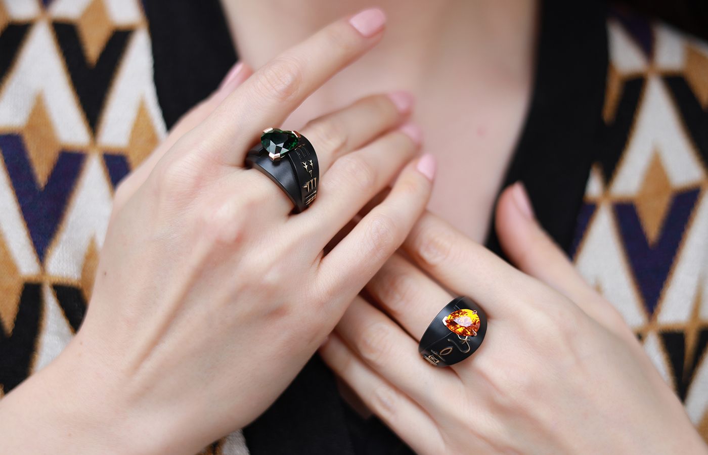 Two rings from the Philippe Guilhem Mashandy Origyne collection including the Imisy ring with a 6.14 carat tsavorite and Cuneiform script (left) and another with a 5.02 carat Mandarin garnet and Egyptian hieroglyphs in bronze and rose gold