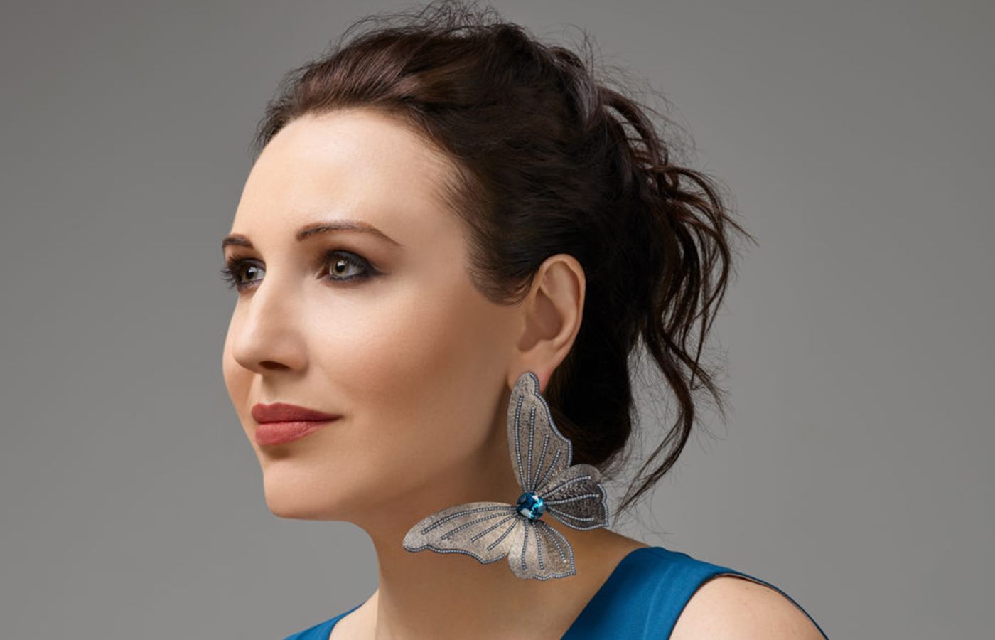 Katerina Perez wears a statement butterfly single earring with blue zircon