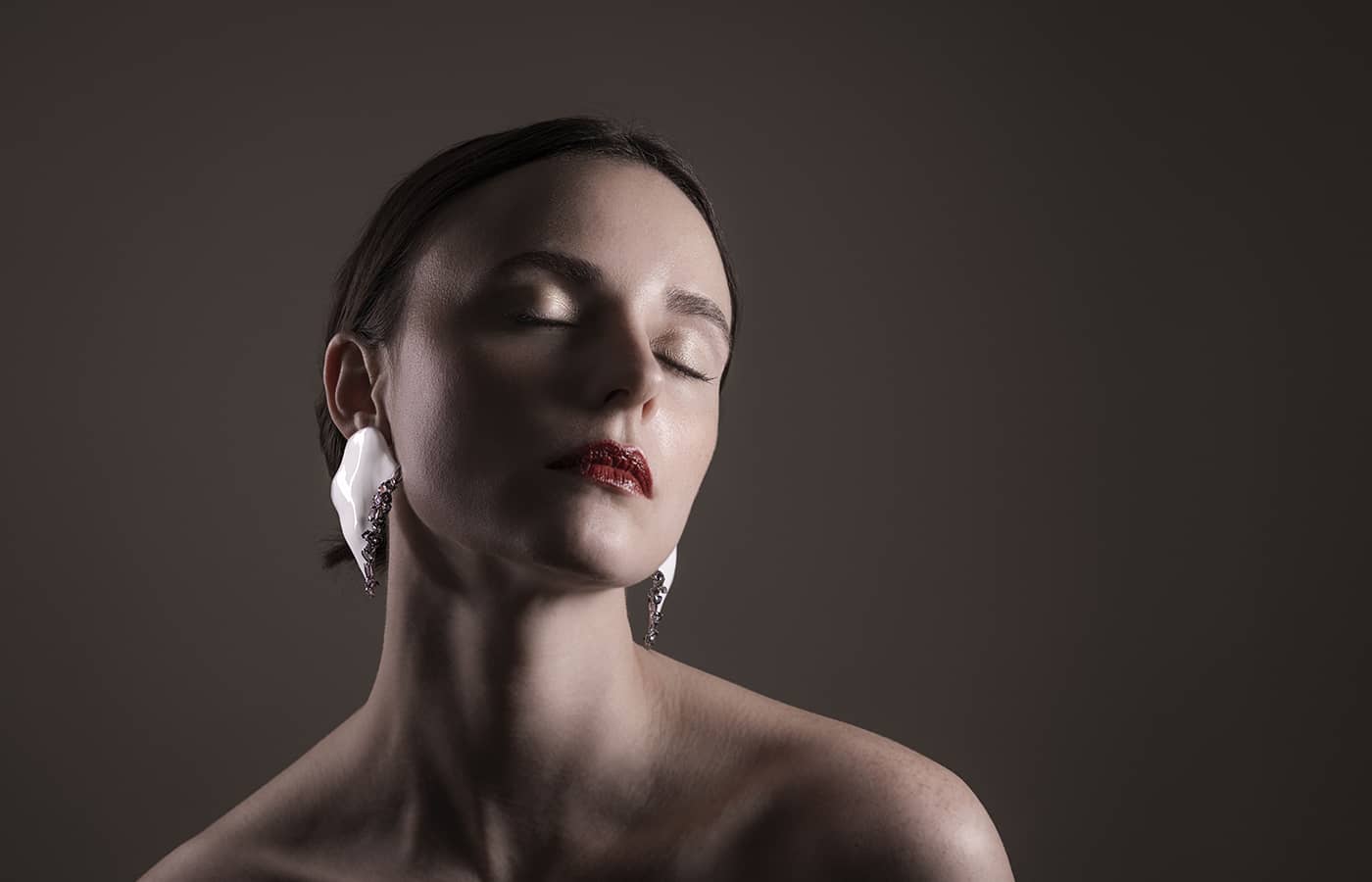  Model wearing Feng J Coeur Blanc earrings in white lacquer and coloured gemstones