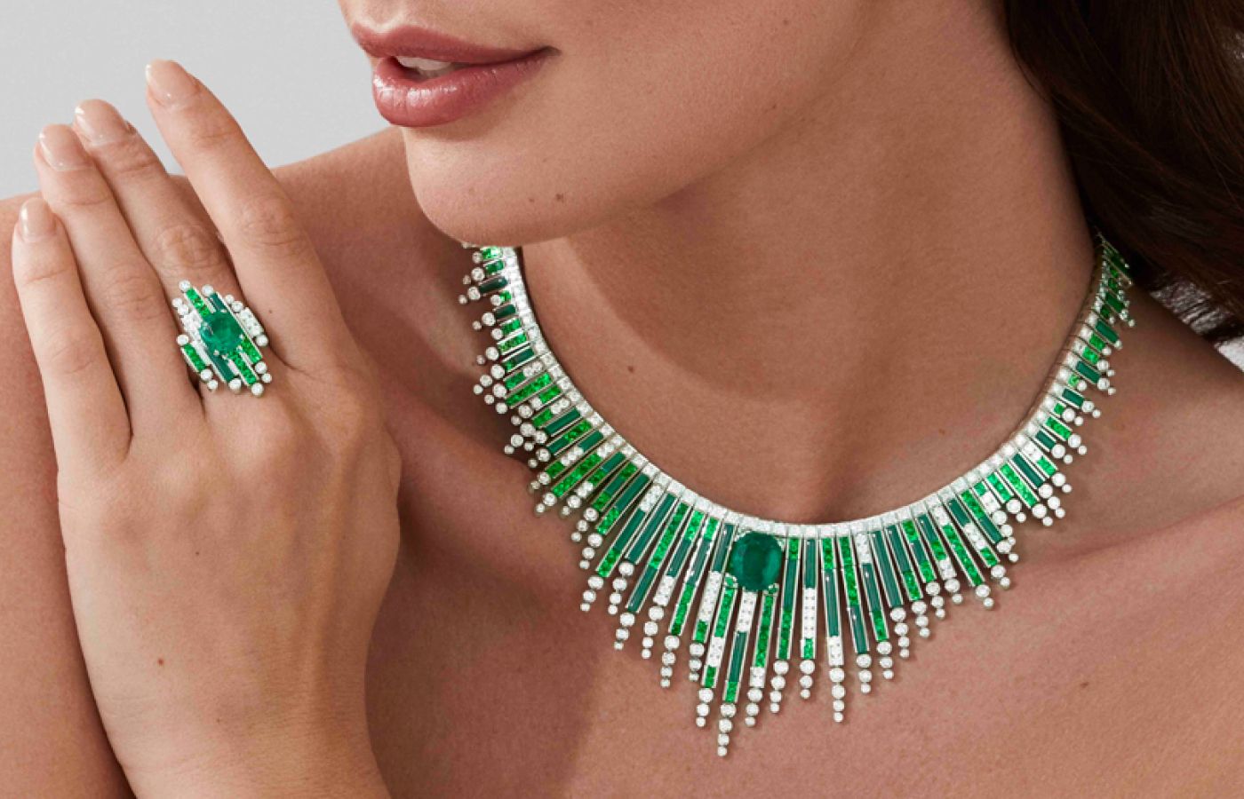 Model wearing Garrard Amazonia earrings and ring in white gold, emerald, diamond, tsavorite and malachite from the Couture High Jewellery collection