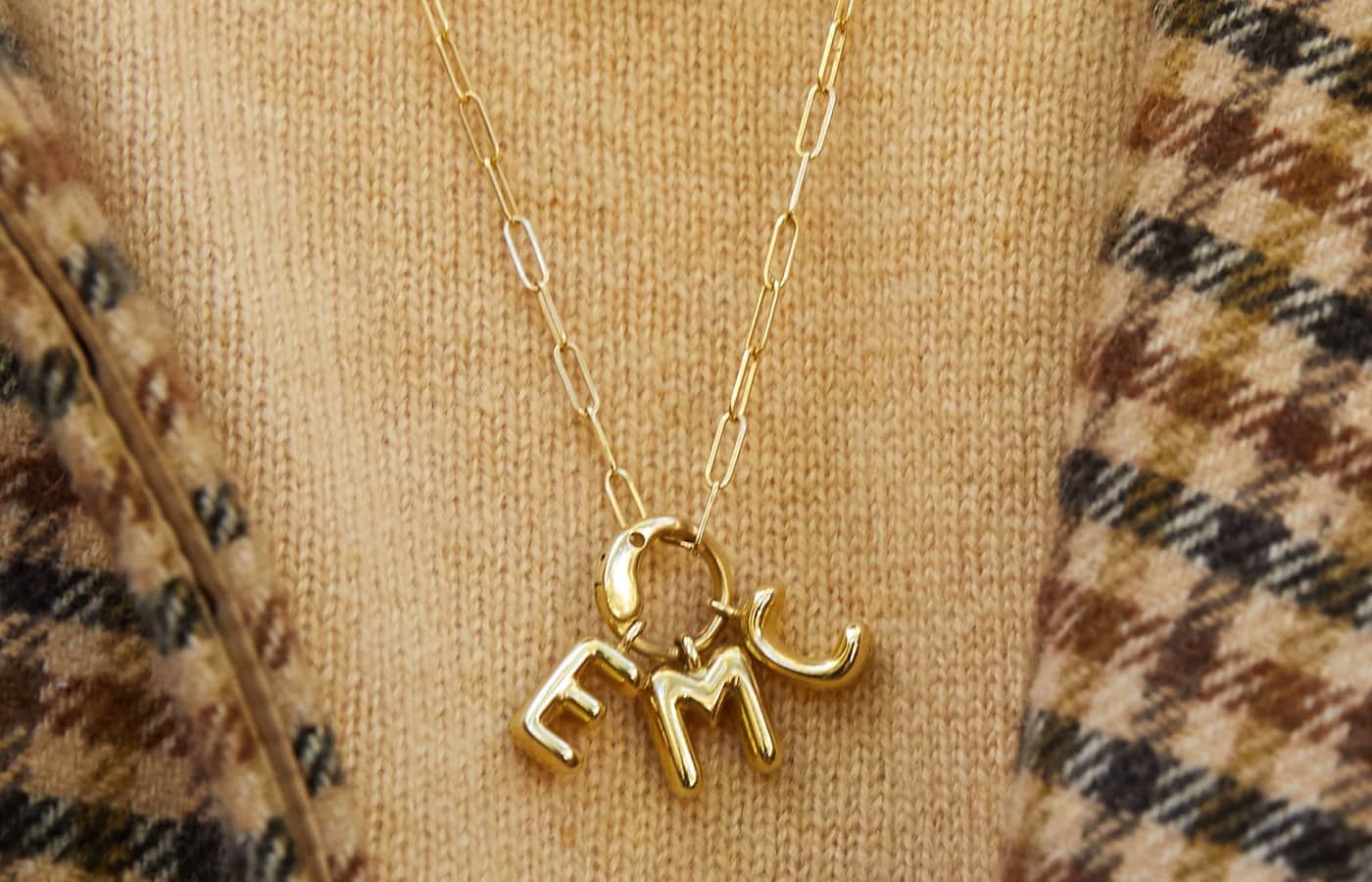 Model wearing Elizabeth Moore Alphabet EMC necklace in gold