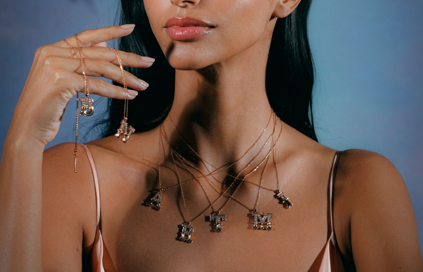  Model wearing Letter pendants in gold and diamonds 