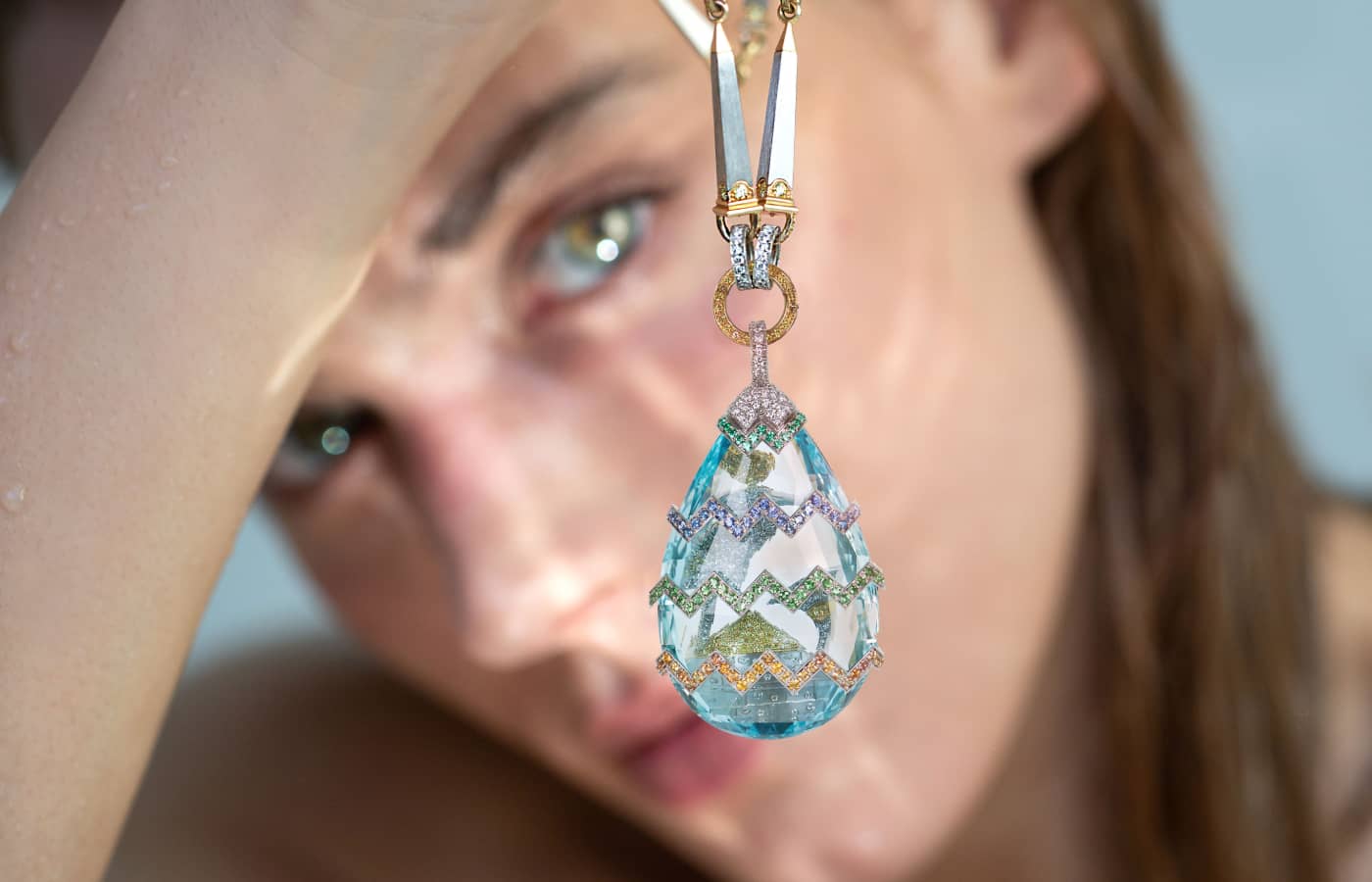 Model holding a Seijo aquamarine and coloured gemstone pendant