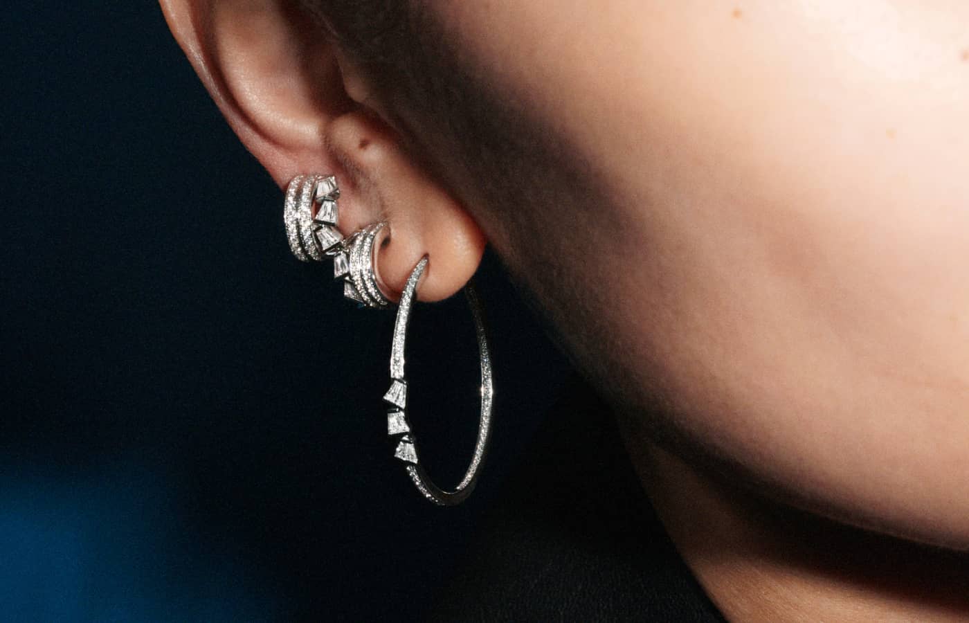 A model wears Rock Diamonds earrings by Bucherer Fine Jewellery with trapezoid- and round brilliant-cut diamonds