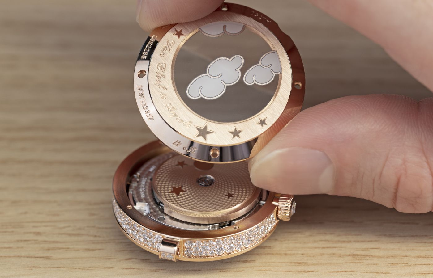  The back of the Van Cleef & Arpels Lady Féerie  Or Rose watch features hand-drawn enamel clouds