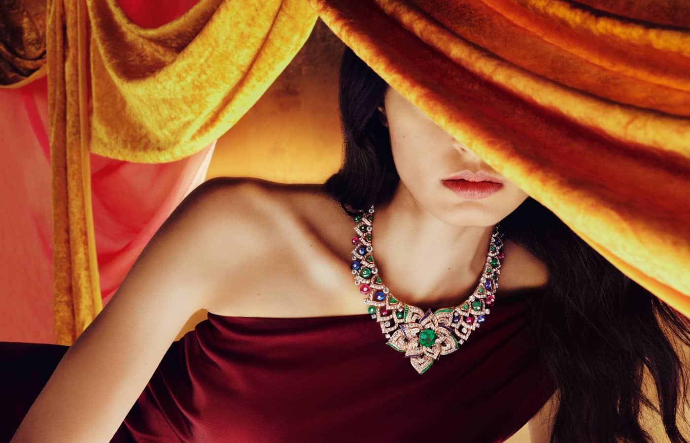 A model wears the Oriental Buds necklace with a 13.34 carat antique cushion-cut emerald from Colombia, surrounded by Byzantine-inspired patterns of diamonds, pink tourmalines, sapphire and emerald beads from the East Meets West chapter of the Bulgari Mediterranea High Jewellery Collection