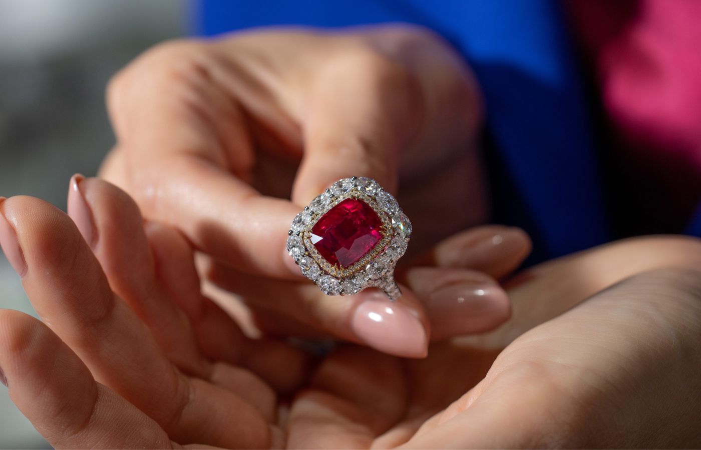 Omi Privé cocktail ring in platinum and gold, featuring a 10.09-ct cushion-cut ruby and oval diamonds