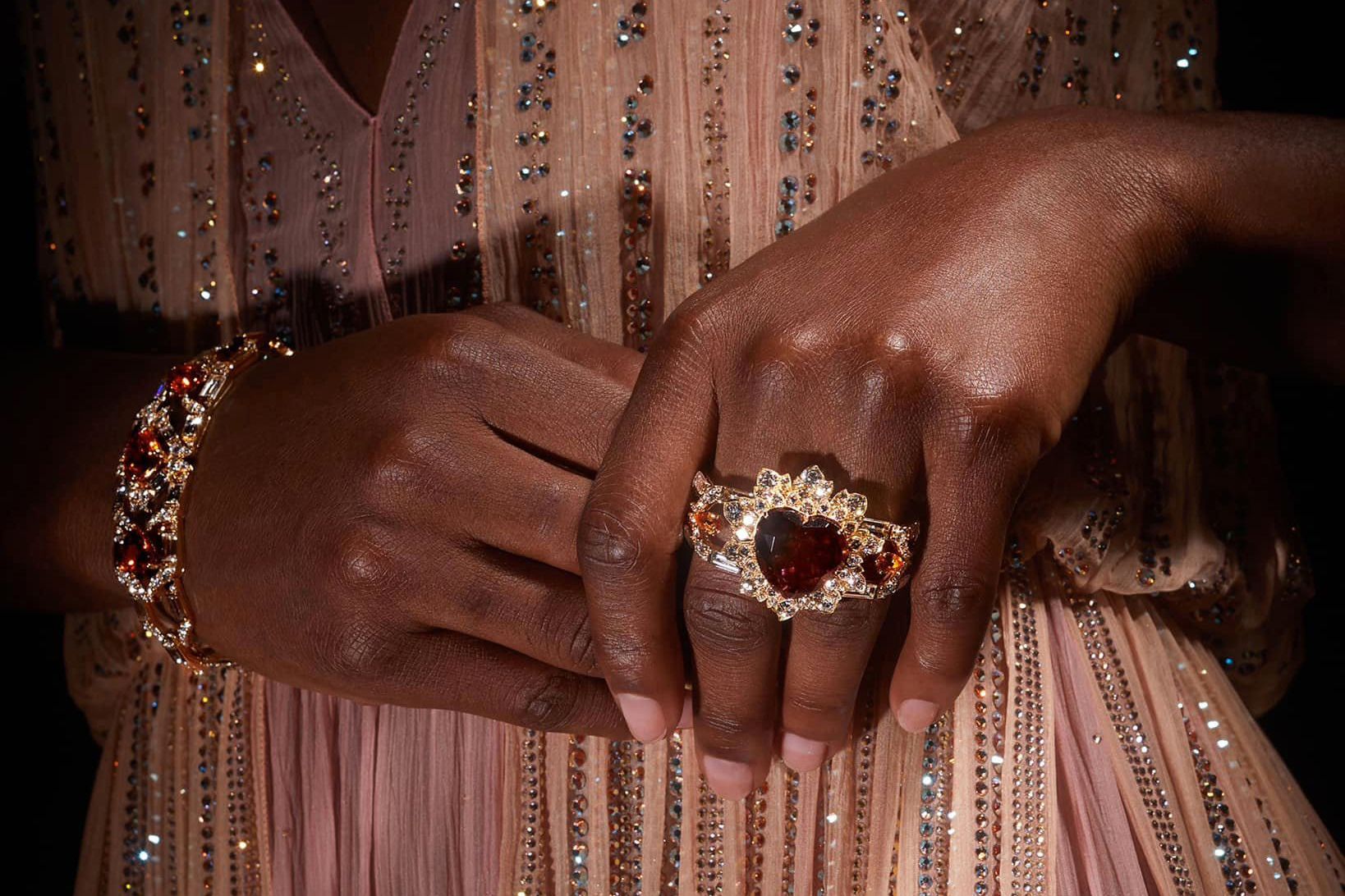  Model wearing Gucci High Jewellery multi finger ring in gold, pink tourmaline, mandarin garnets and diamonds from the Gucci Allegoria High Jewellery Collection