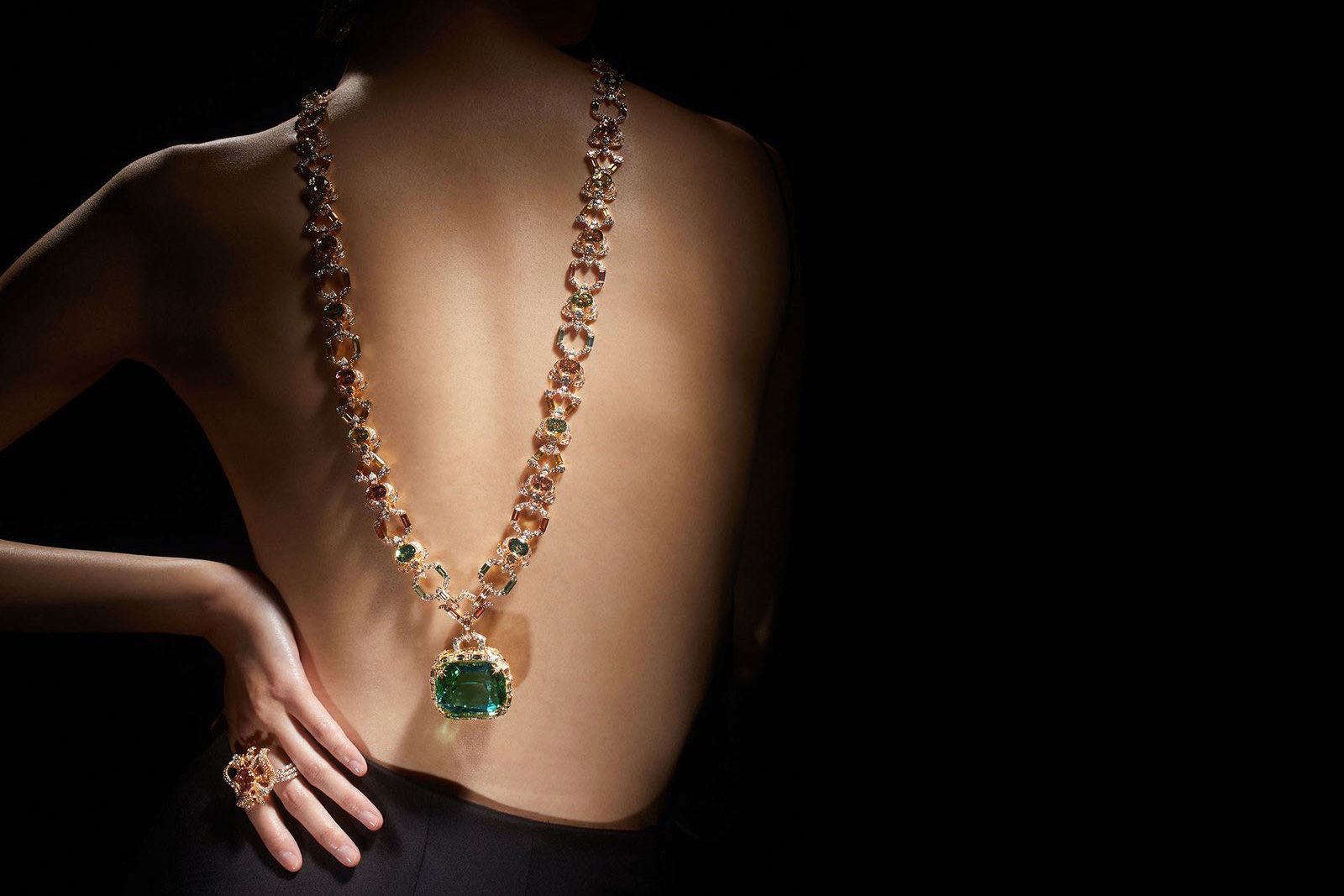 Model wearing Gucci High Jewellery necklace in gold, enamel, green tourmaline, fancy tourmalines and diamonds, as well as a multi finger ring in gold with rubellite and diamonds from the Gucci Allegoria High Jewellery Collection