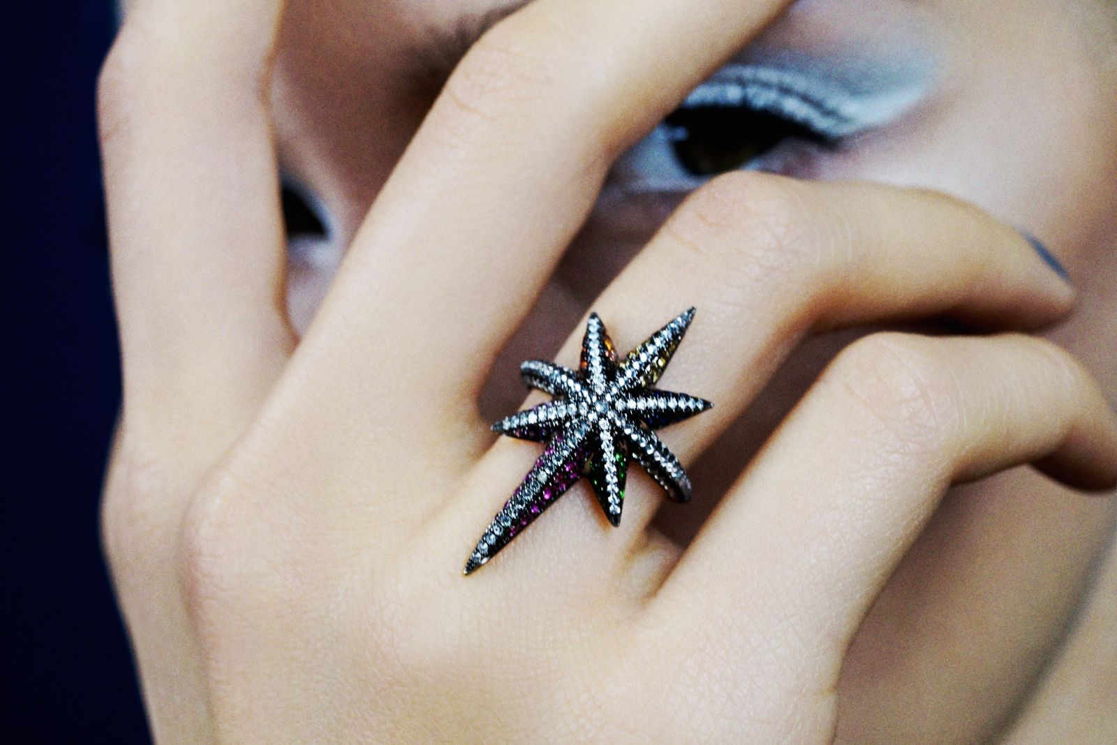 Model wearing Venyx Rainbow Star ring in gold, black rhodium, multicolour sapphires, tsavorite garnet and amethyst