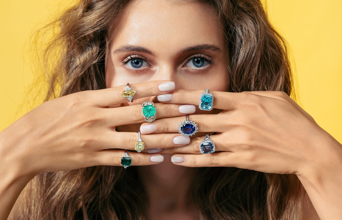 Model wearing a selection of Parure Atelier High Jewellery rings featuring rare natural gemstones