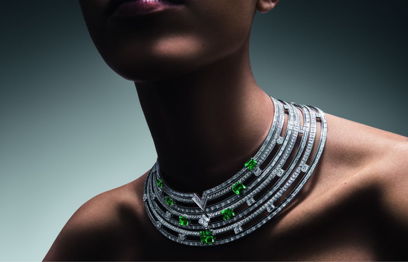 Model wearing Louis Vuitton Gondwana High Jewellery necklace in white gold, platinum, emerald, LV Monogram Flower cut diamond and diamonds from the Deep Time High Jewellery Collection