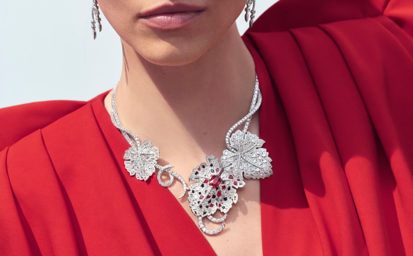 Model wearing the Chaumet Feuille de Vigne necklace in white gold, ruby, grey and black spinels and diamond from Le Jardin de Chaumet High Jewellery collection