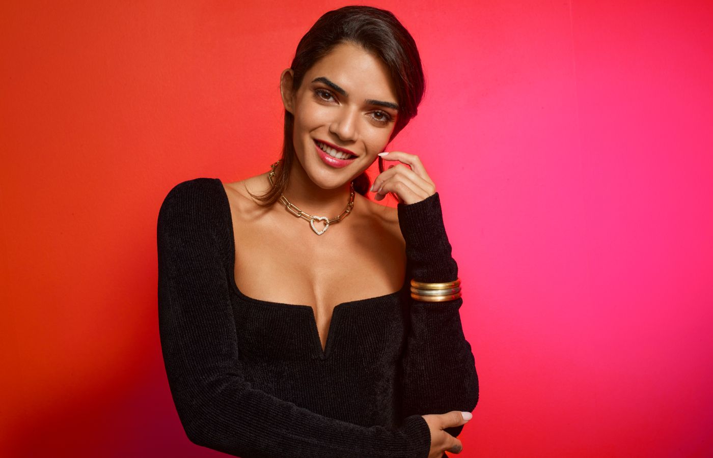  A model wears a Robinson Pelham Identity necklace with an Identity Heart Connector, all in 18k yellow gold, plus a stack of Romy bangles in 14k white, yellow and rose gold