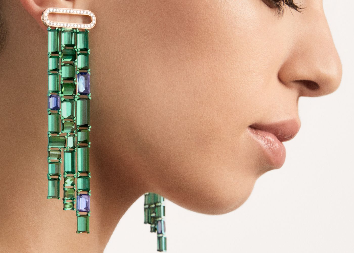 Model wearing Giardini Verticali earrings in rose gold, titanium, green tourmalines, tanzanites and diamonds from the Ode to Milan High Jewellery collection