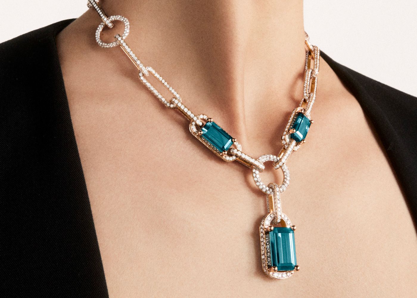 Model wearing Pomellato Giardini Verticali necklace in rose gold featuring 3 emerald-cut indicolites from the Ode to Milan High Jewellery collection