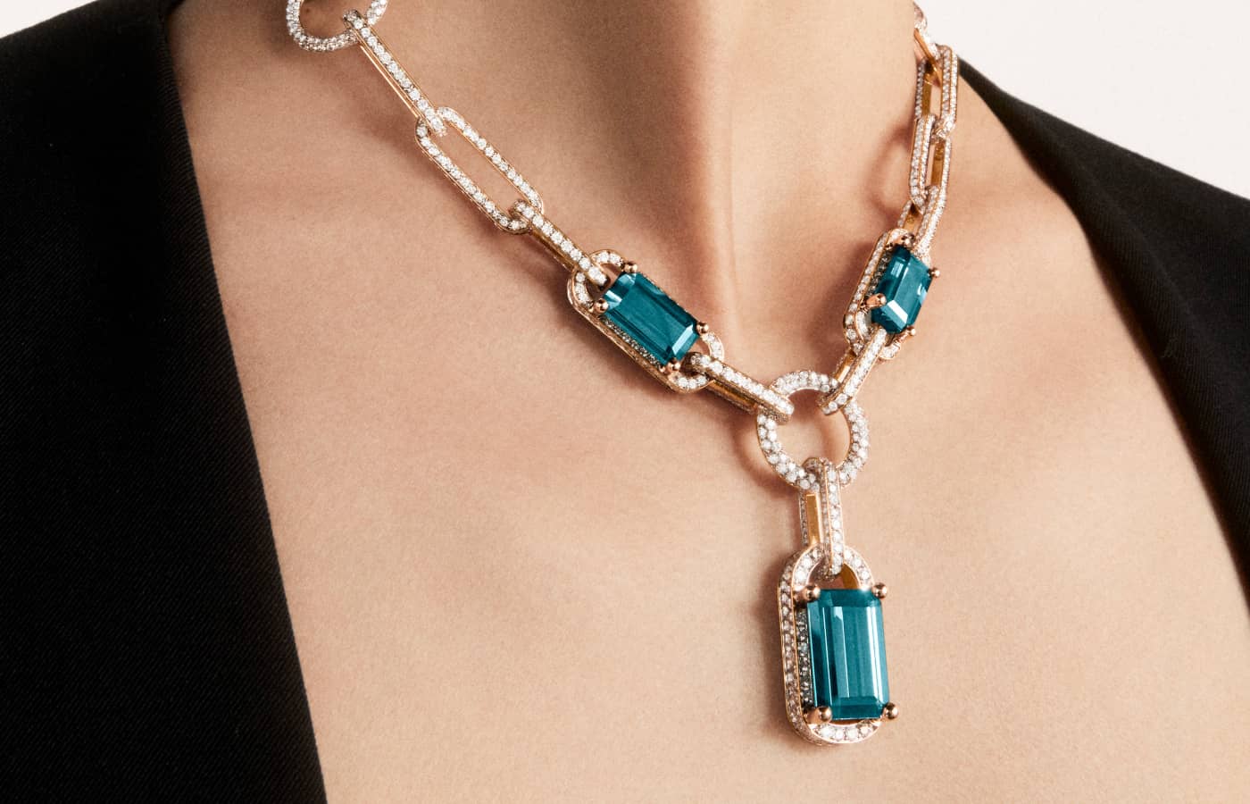 Model wearing Pomellato Giardini Verticali necklace in rose gold featuring 3 emerald-cut indicolites from the Ode to Milan High Jewellery collection