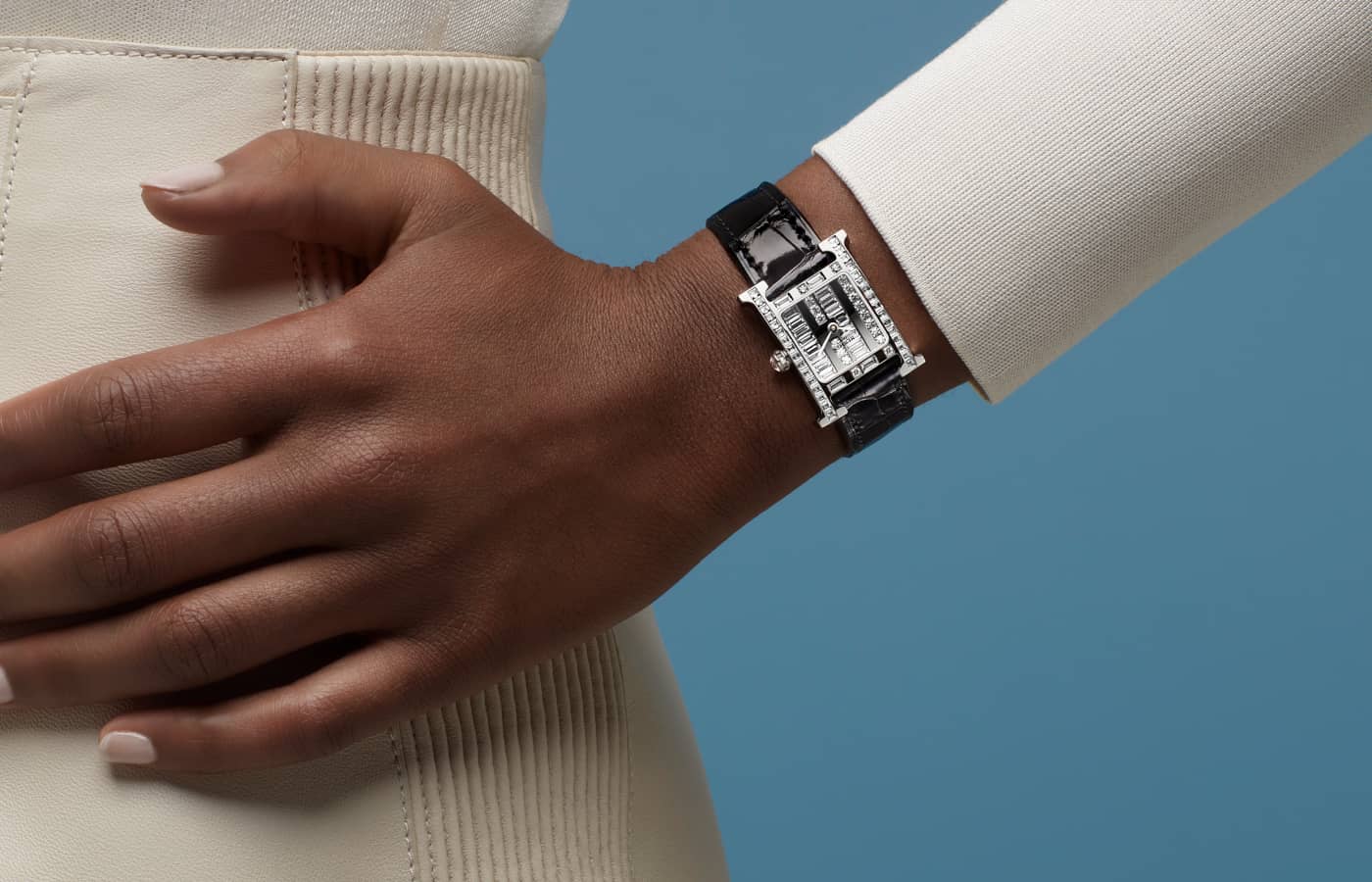 Model wearing Hermès Heure H Vibration watch in white gold and diamond on a black leather strap