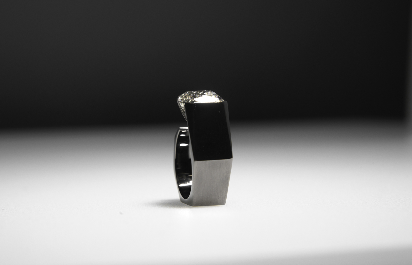  Dina Kamal Transformer Cushion ring in blackened gold featuring a cushion-cut diamond