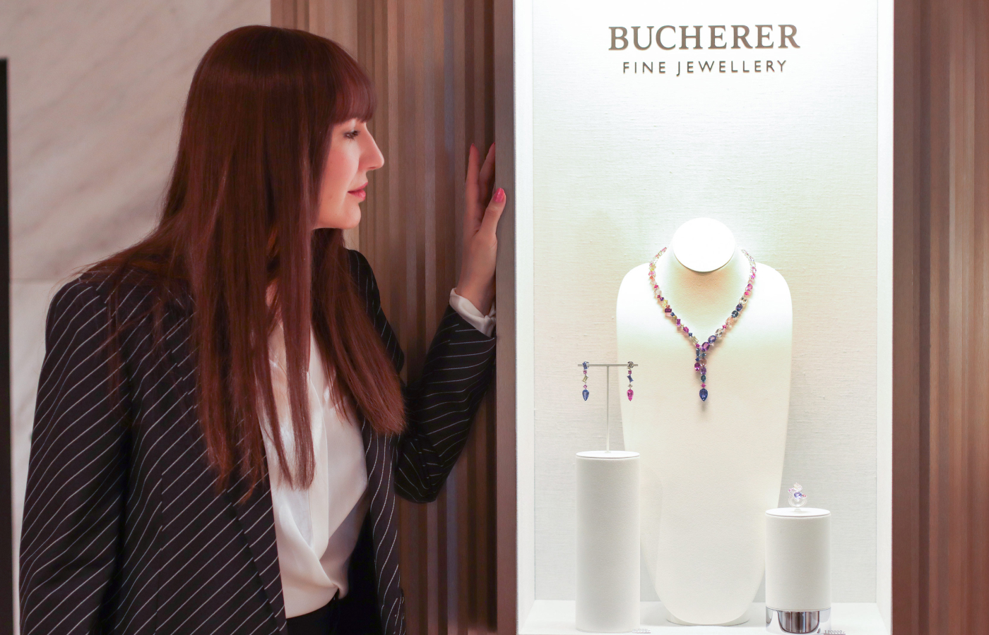 Katerina Perez standing next to a jewellery display case at the Bucherer Fine Jewellery salon