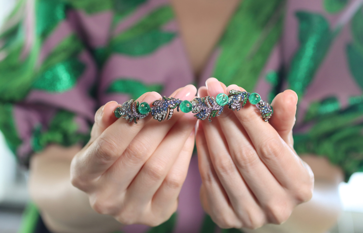 Katerina Perez holding the Loriini earrings in emerald, multicoloured gemstones and diamond by Neha Dani