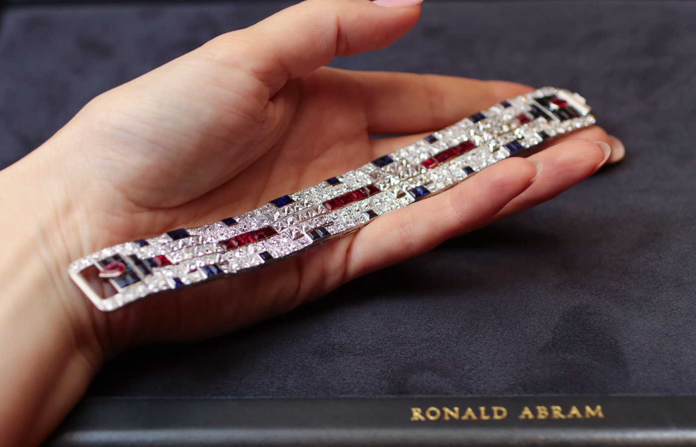  An Art Deco diamond, ruby and sapphire bracelet by Cartier, circa 1930, presented by Ronald Abram