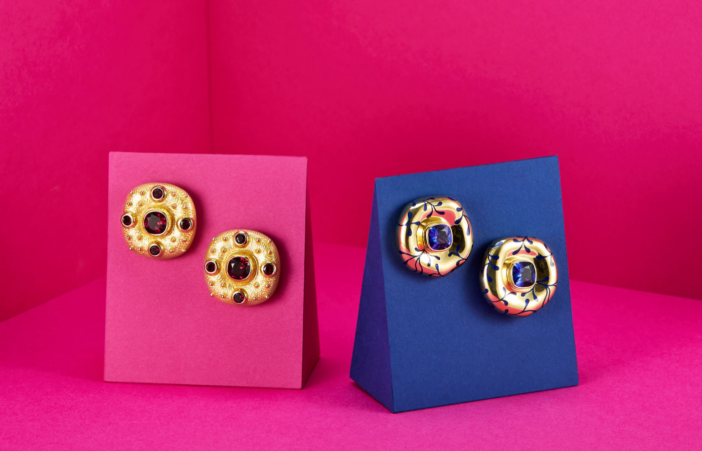  Elizabeth Gage Rhodolite Garnet Ottoman earrings in gold and garnet, alongside a pair of Tanzanite earrings in gold, enamel and tanzanite