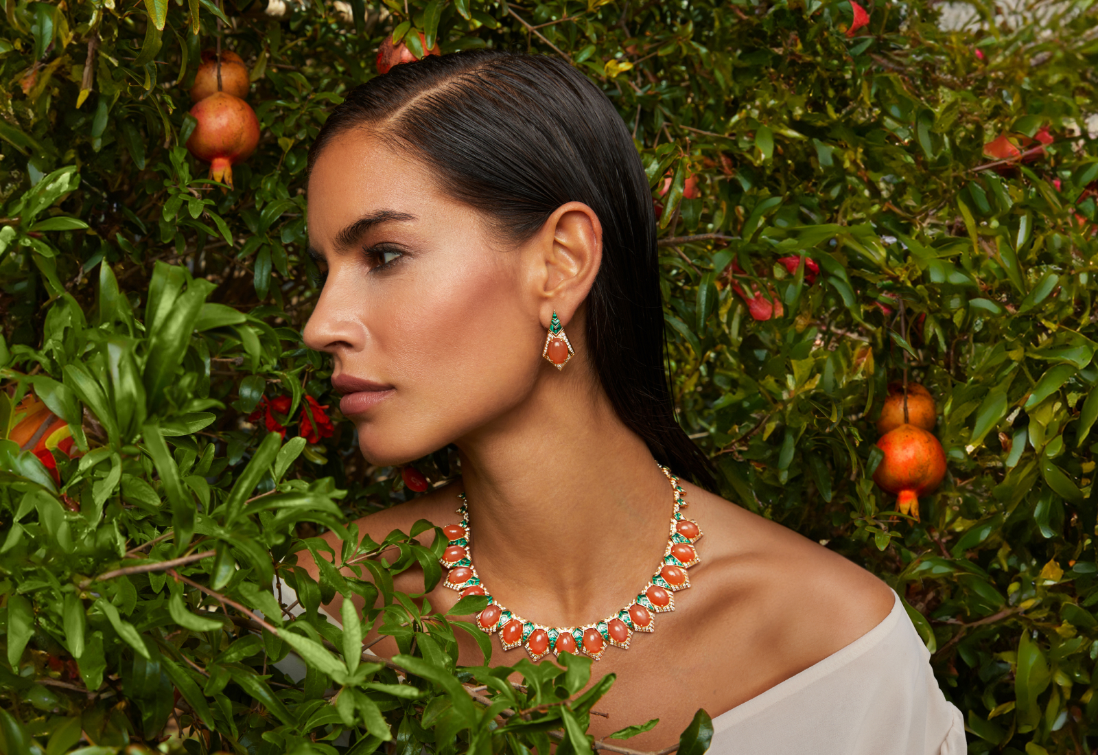 A model wears the Al Zain Zara necklace and matching Zara earrings, with more than 120 carats of peach moonstones, 20 carats of malachite and more than 7 carats of diamonds in 18k yellow gold, from the Jena High Jewellery collection 