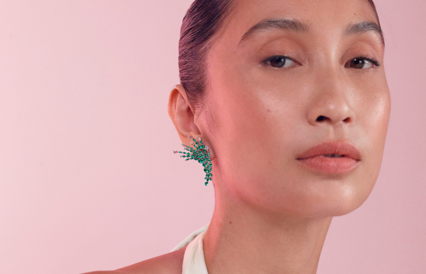 Model wearing Muzo Emerald Colombia Karri earrings in gold, platinum,  Muzo Emeralds and Argyle pink diamonds from the Green Jewel Tradition collection