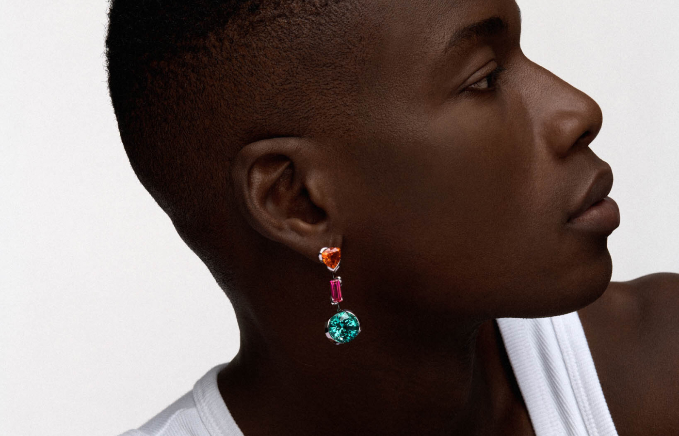 Model wearing Reza Triple Drop earring in white gold, garnet, tourmaline and sapphire