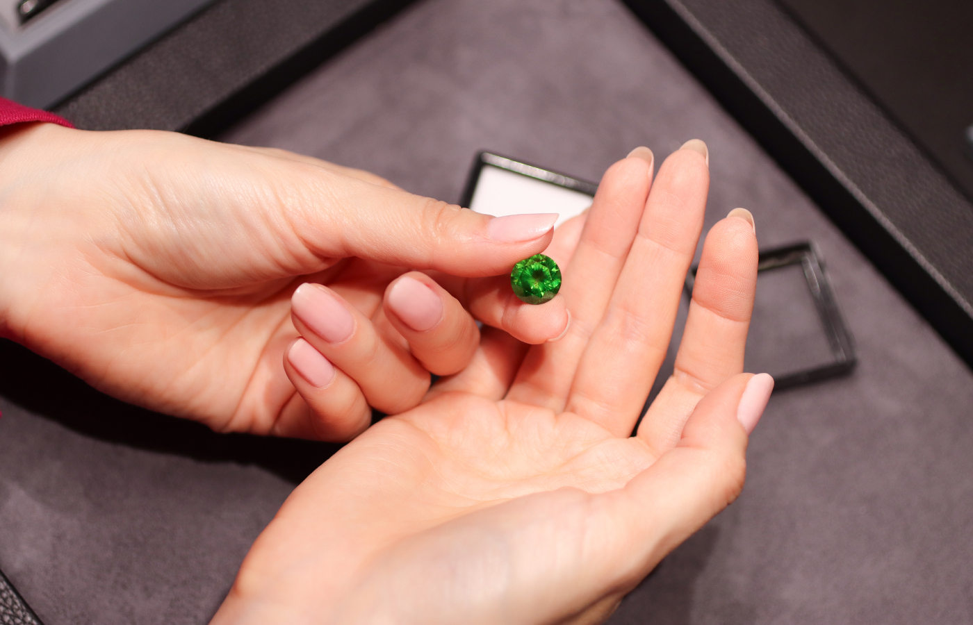 Katerina Perez holds a round-cut Russian demantoid garnet supplied by Tsarina Jewels