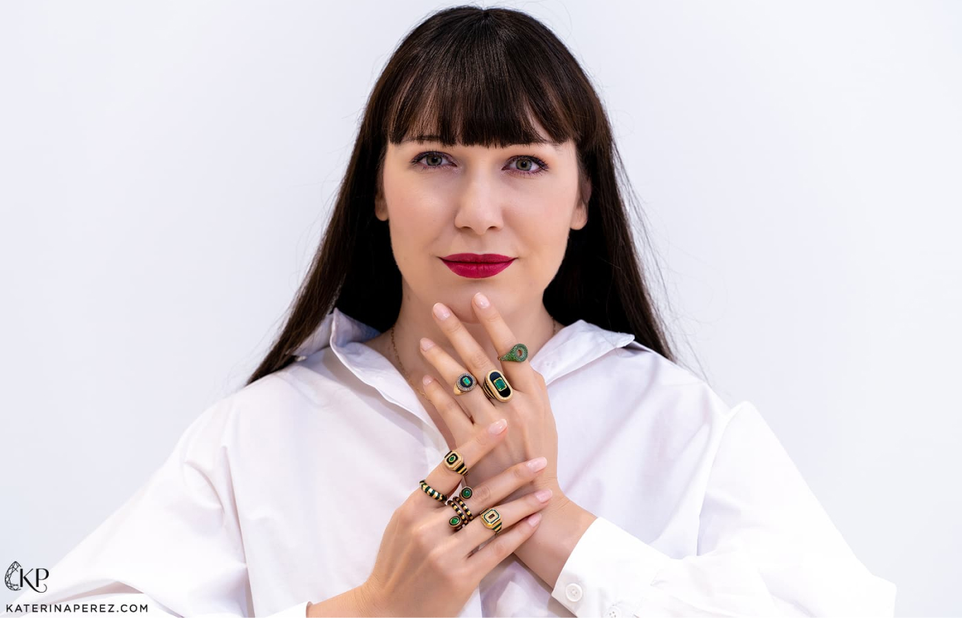  Katerina Perez wears a selection of malachite, emerald, yellow gold and black enamel ring designs by State Property