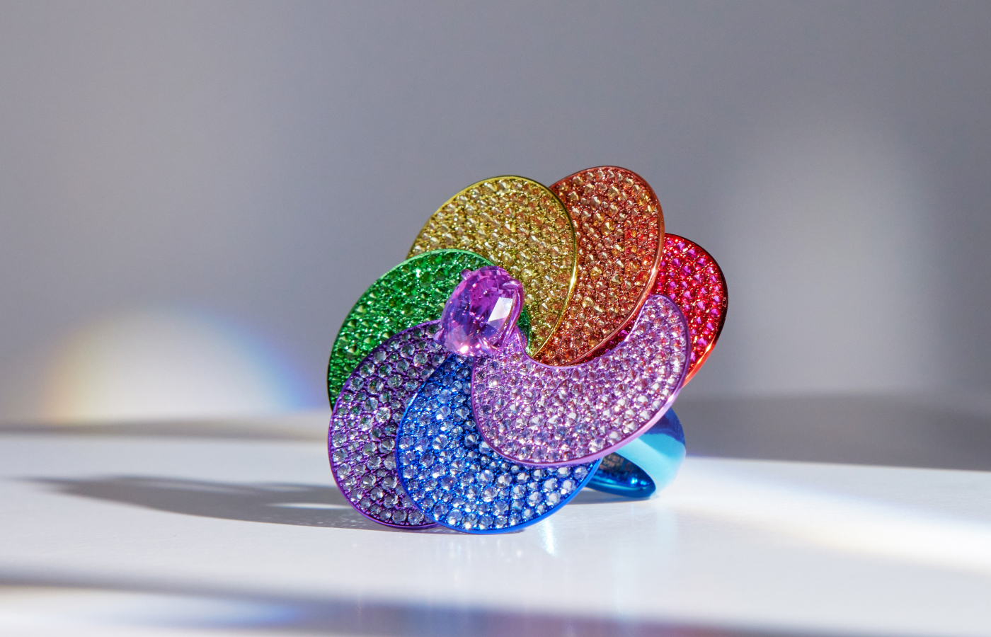  Faith Jewels Rainbow ring with a central 5.02-carat oval-cut indigo sapphire, plus more than 800 rubies, sapphires, and tsavorites, set in rainbow toned titanium