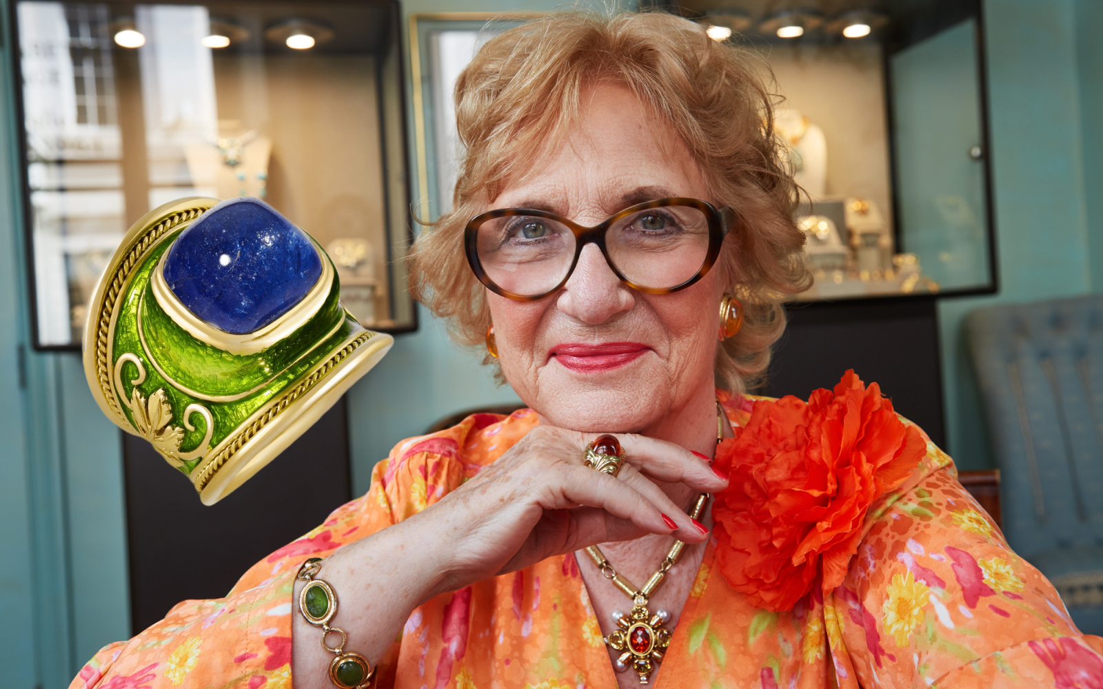Elizabeth Gage MBE – Founder and Creative Director at Elizabeth Gage, wearing a selection of her own creations, alongside her Tanzanite Vine Leaf Tapered Templar ring in gold, lime-green enamel, featuring a 12.46-ct tanzanite 