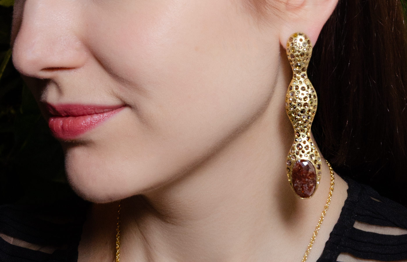 Katerina Perez wears a pair of Todd Reed earrings in 18k yellow gold with burgundy fancy-cut diamonds of 19.87 carats and brown/cognac rose-cut diamonds of 14.99 carats