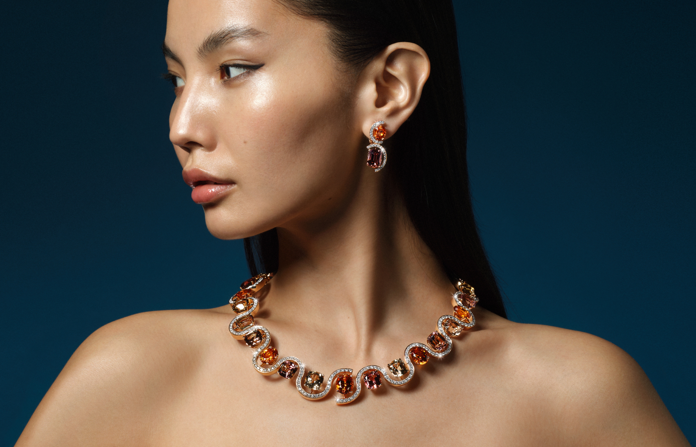A model wears a Bucherer Fine Jewellery necklace with oval-shaped mandarin garnets, 20 tourmalines and 340 brilliant-cut diamonds set in 18k rose gold, complete with matching earrings, from the Manhattan High Jewellery collection