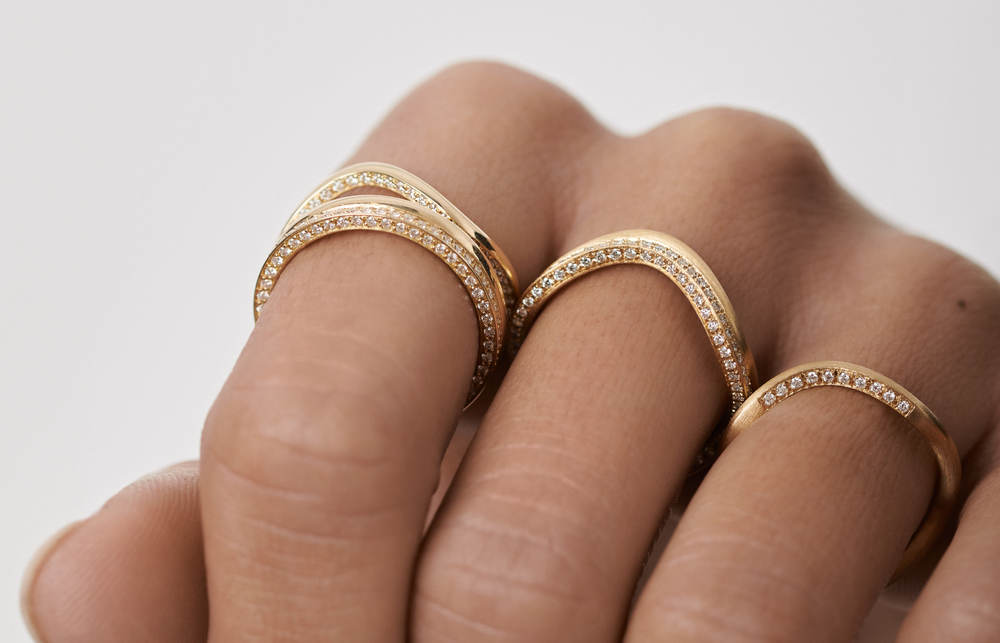 Model wearing a series of Sève Resilience rings in gold and diamond