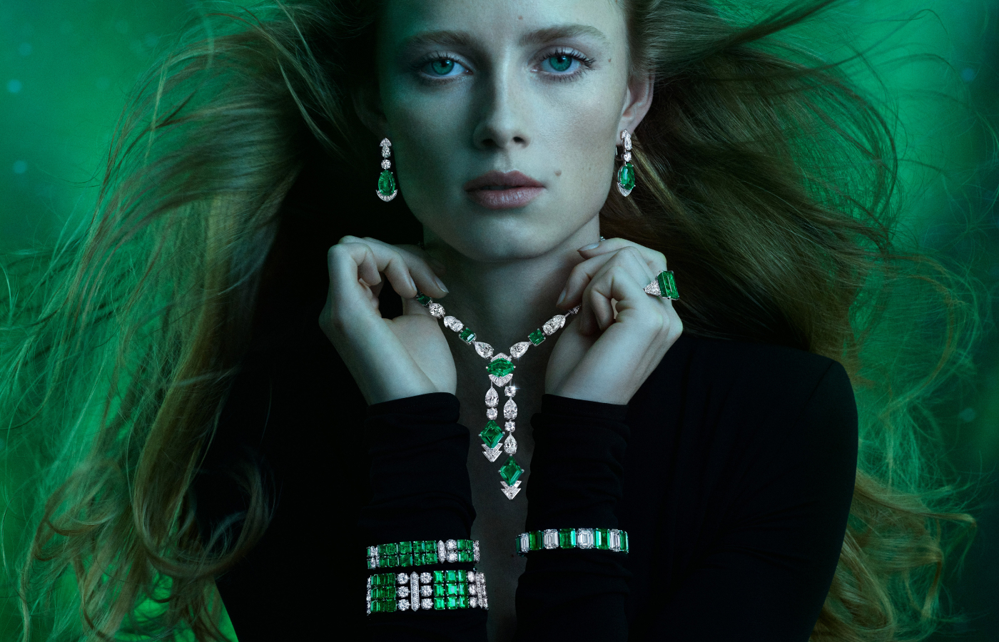 Model wearing Graff Galaxia earrings, necklace, ring and bracelets in platinum, white gold, emerald and diamond