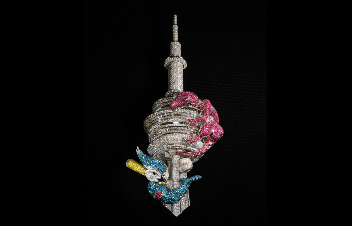  This pendant—designed by Alex Moss in 2023 to celebrate Drake’s hometown of Toronto—boasts multicolored diamonds and rubies on 18K gold and features the mascots for the Toronto Raptors and the Toronto Blue Jays wrapped around Toronto’s CN Tower.  Alvaro Keding/© AMNH