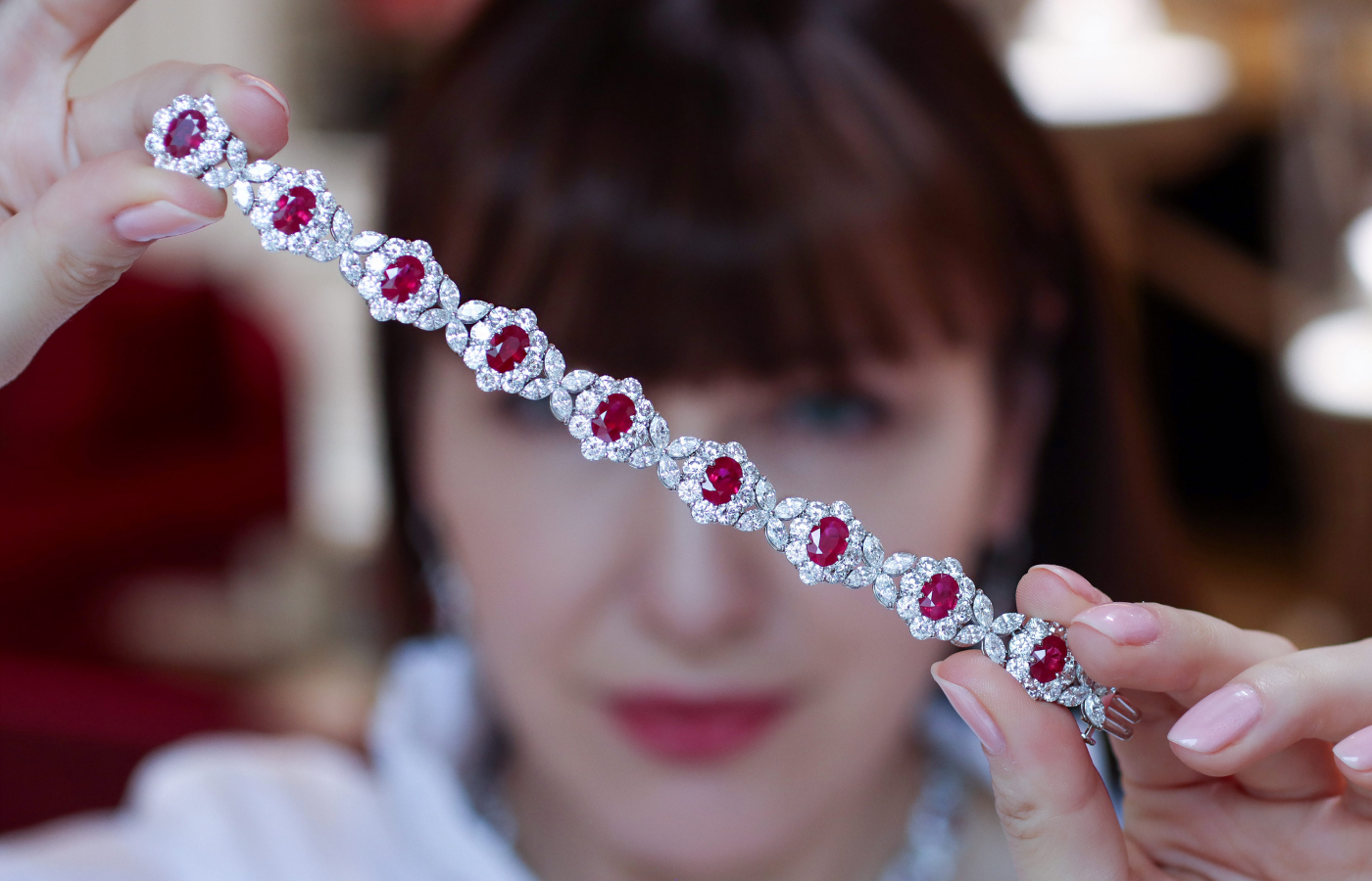  Katerina Perez holding a Bayco necklace in platinum and gold set with 33-cts of pigeon's blood Burma rubies and 41-cts of diamonds