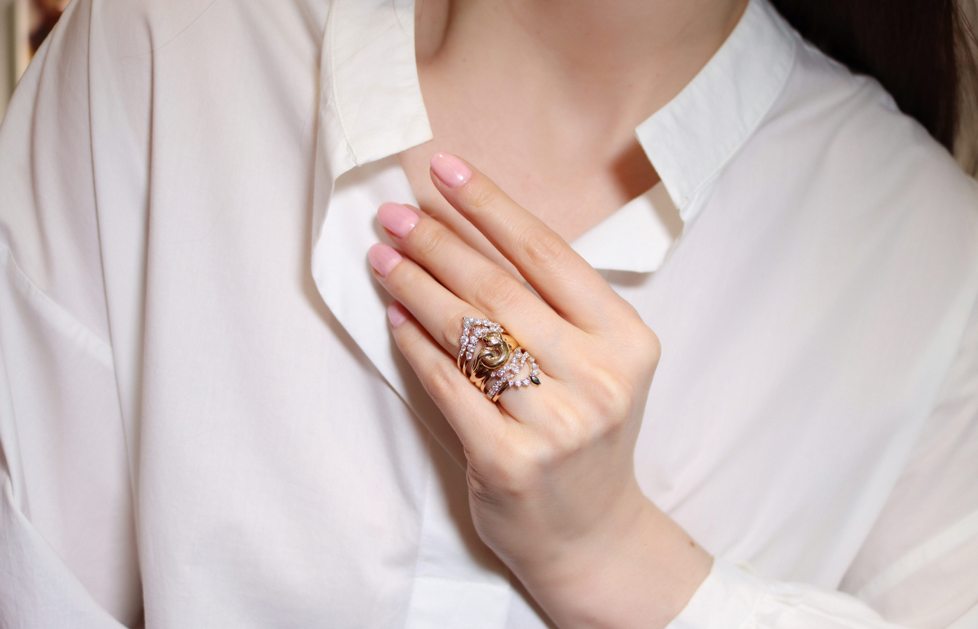 Katerina Perez wearing Anna Sheffield Victorian Serpent ring in gold, reclaimed white diamond melee and various Nesting Bands